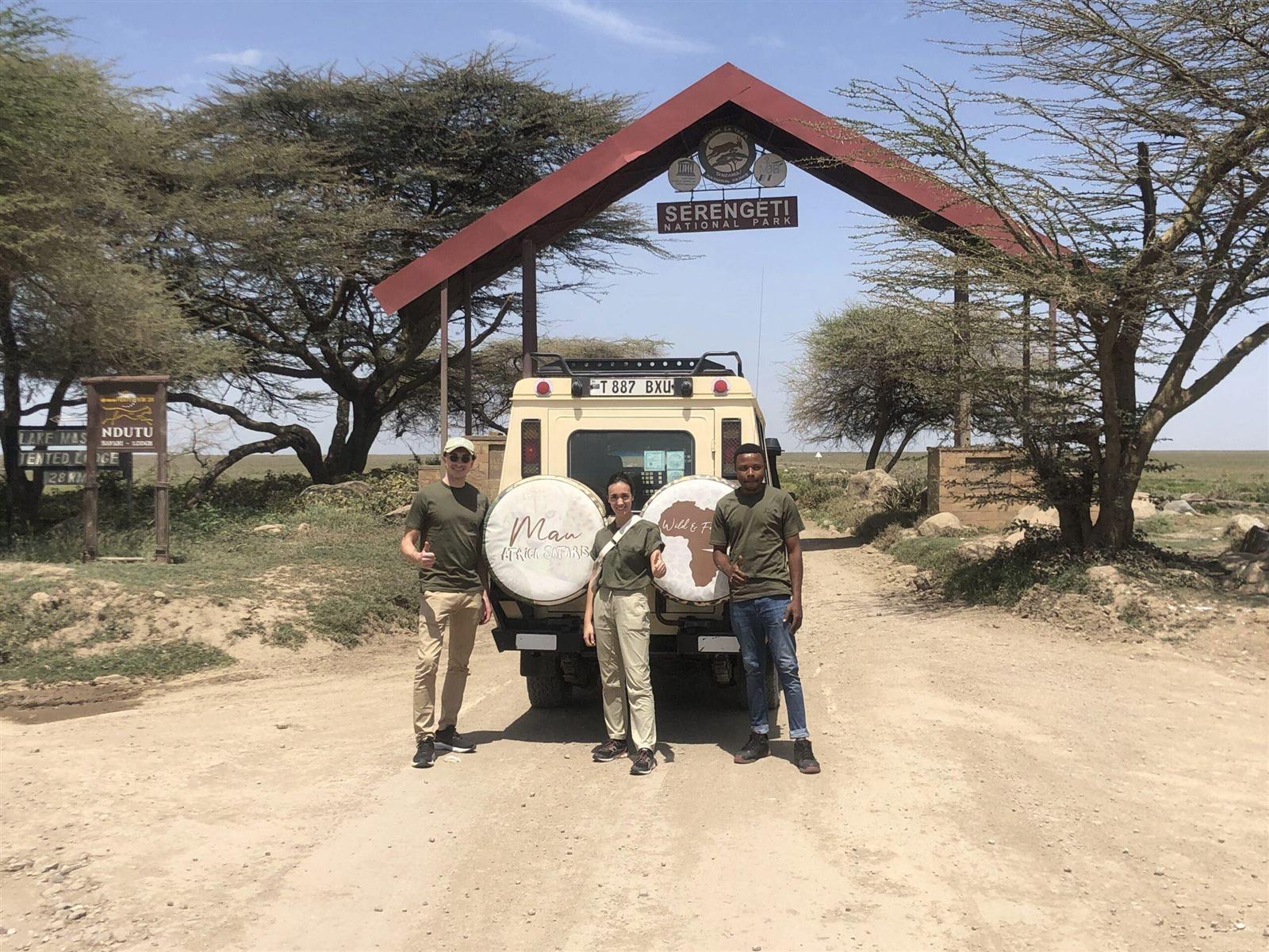 The Mau Africa Safaris team with their Land Cruiser at a park gate